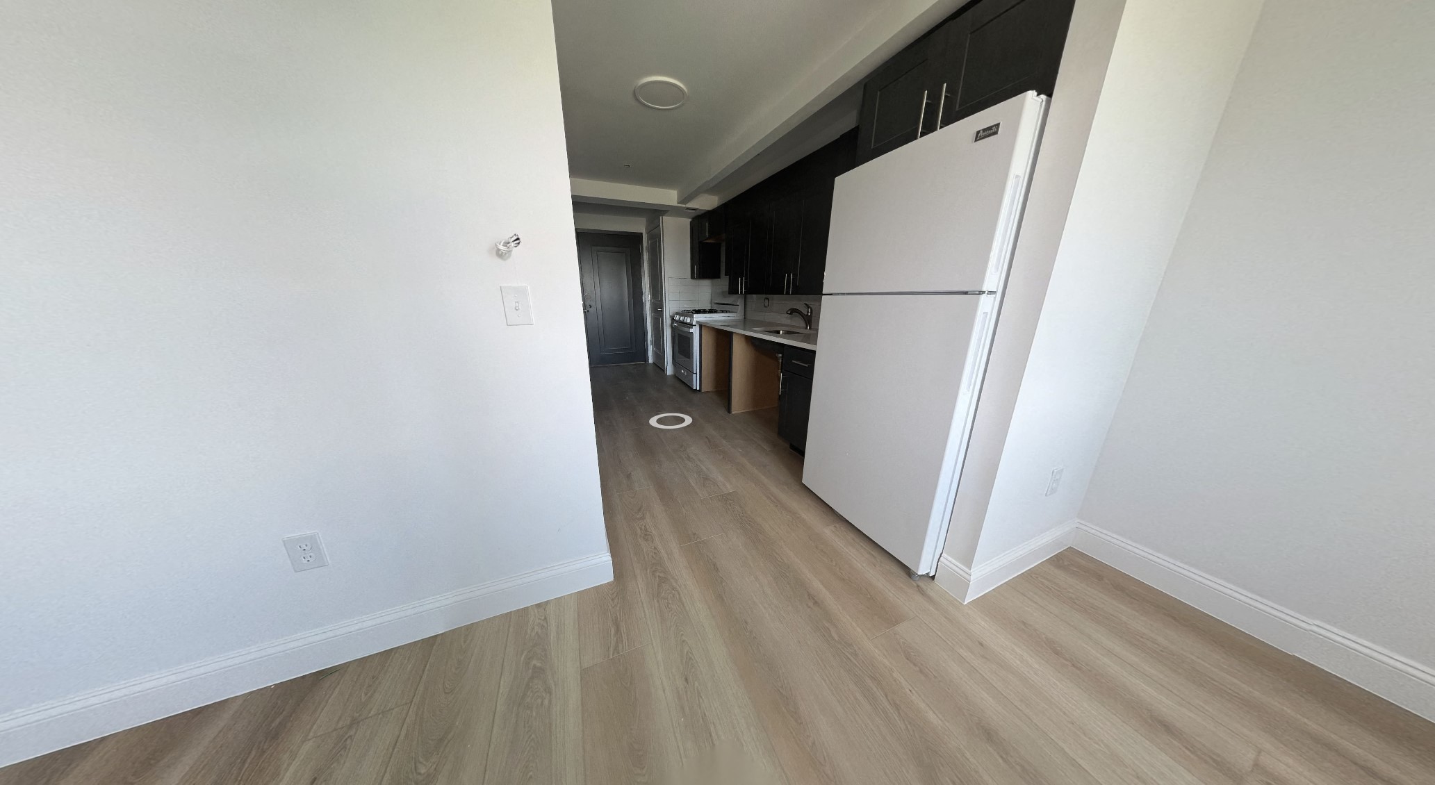 a renovated apartment with a refrigerator and a kitchen